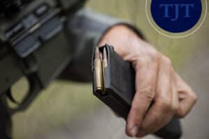 Hand loading a magazine into a rifle illustrating firearm possession charges that trigger mandatory Graves Act sentencing in New Jersey