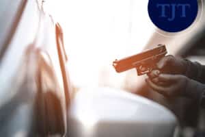 Person holding a handgun inside a vehicle illustrating a firearms offense that may trigger Graves Act mandatory prison sentences in New Jersey